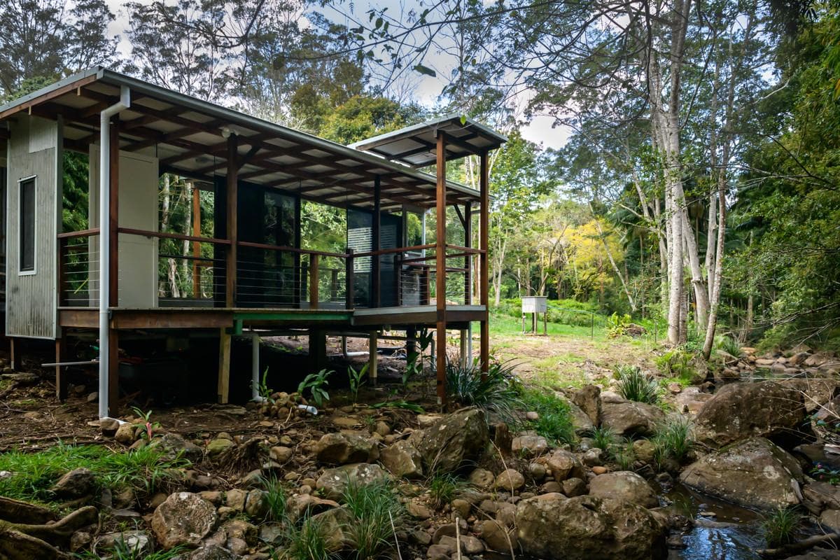 Mirrored outdoor shower at The Creek House surrounded by rainforest